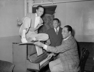 Charles "Teenie" Harris - Duke Ellington at piano, with Billy Strayhorn looking on, and possibly dancer Ralph Brown on top, backstage in Stanley Theatre, ca. 1940–1946