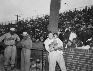 Charles "Teenie" Harris - Boxer Joe Louis holding baby cousin Joe Louis Barrow, with Joe Louis Bombers softball teammates on Greenlee Field, Hill District, 1938