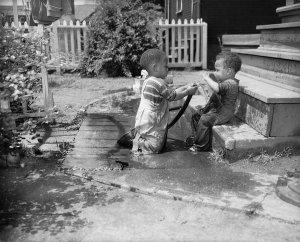 Charles "Teenie" Harris - Ira Vann Harris spraying his brother Lionel Harris with garden hose, Homewood, Pittsburgh, 1948