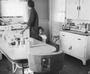 Charles "Teenie" Harris - Elsa Elliott Harris with Cheryl "Tiny" Harris, in kitchen of Harris home, 7604 Mulford Street, Homewood, ca. 1958