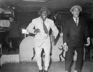 Charles "Teenie" Harris - Two men dancing on bandstand, with musicians, including Ruby Young playing piano, ca. 1938-1945