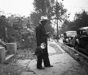 unknown photographer - Charles "Teenie" Harris, holding camera and standing on sidewalk, ca. 1938