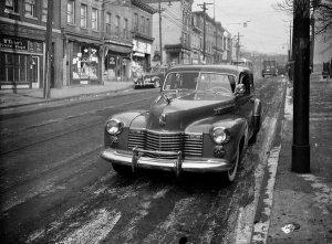 Charles "Teenie" Harris - Cadillac belonging to Charles "Teenie" Harris parked on Centre Avenue, with McTurner's Funeral Chapel in background, Hill District, ca. 1941-1946
