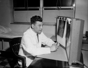 Charles "Teenie" Harris - Dr. Emile Nash seated before unlit light boxes with x-rays, in Veterans Administration Hospital, Oakland, 1955