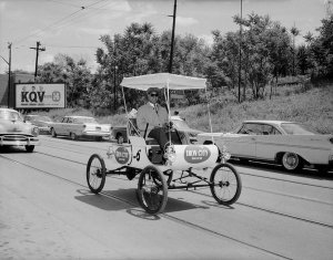 Charles "Teenie" Harris - James Dyer driving horseless carriage with Iron City Beer logos, 1962