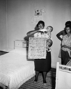 Charles "Teenie" Harris - Daisy Curry, holding protest sign "Do your children live like this in Squirrel Hill? We are still human not animals," 1963