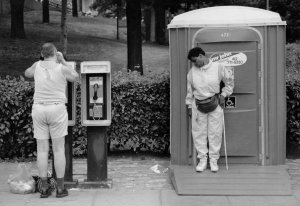 Charles "Teenie" Harris (attributed to) - Man talking on pay phone and woman, possibly blind, standing outside a Mr. John portable toilet