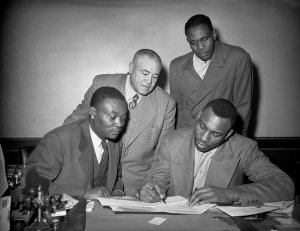 Charles "Teenie" Harris - Rufus "Sonnyman" Jackson, Seward "See" Posey, and another man with Luke Easter signing Homestead Grays contract, 1947