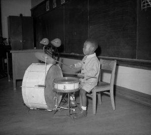 Charles "Teenie" Harris - Young Roger Humphries playing child-size drums in music classroom, ca. 1942